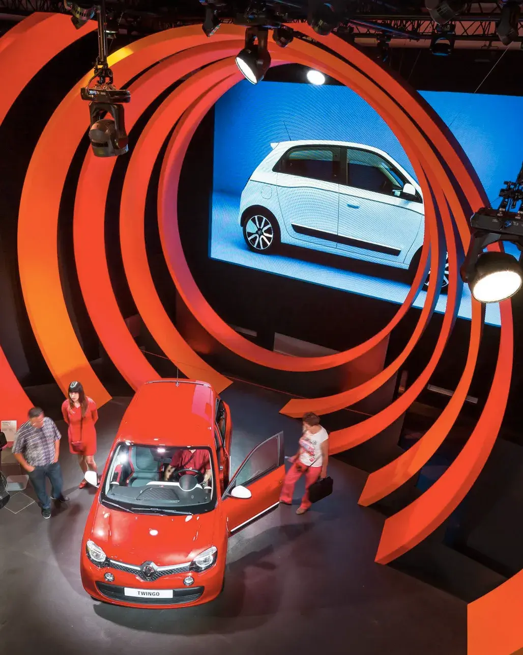 Nouvelle Renault Twingo dans un tunnel de cercles rouges, devant un écran géant diffusant le véhicule.